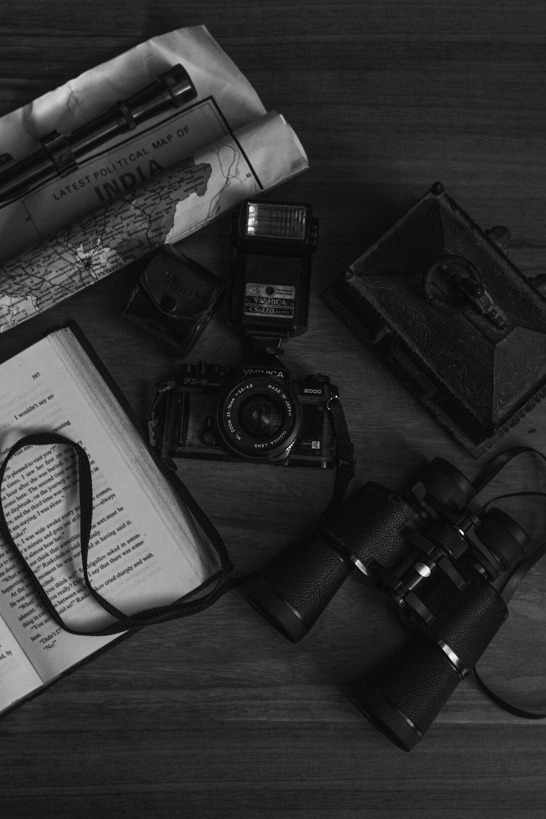 Detective notebook with handwritten notes, magnifying glass and old photographs on a wooden desk